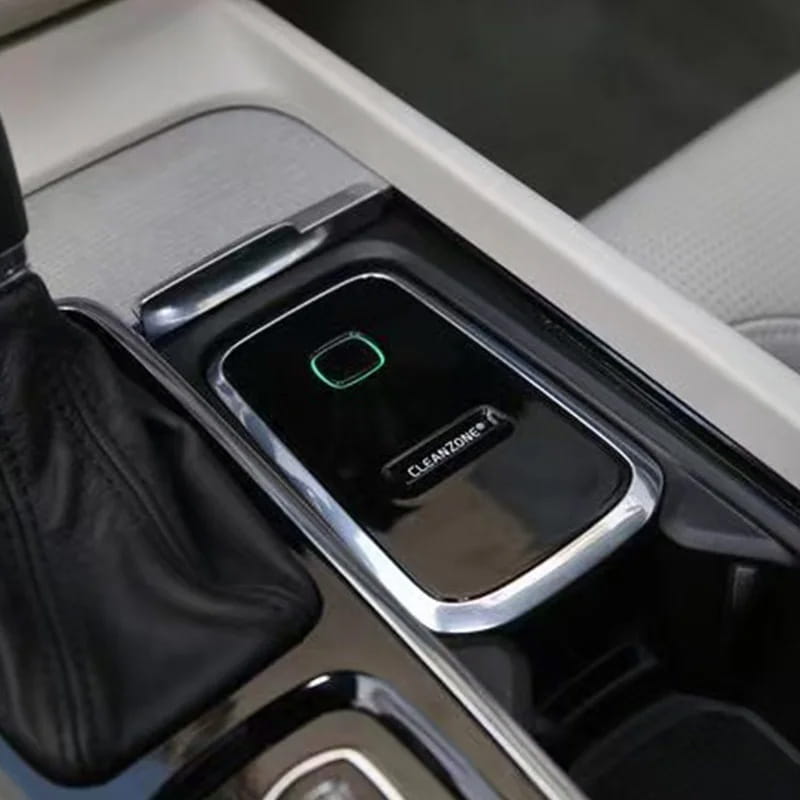 Black rectangular Volvo Cleanzone wireless car charger and air purifier with silver metallic border and green illuminated button.
