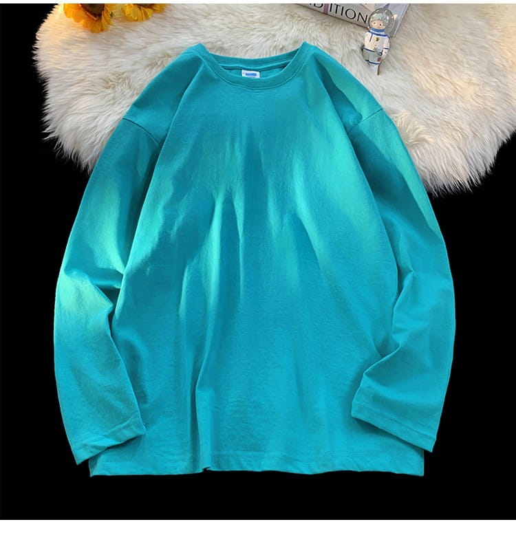 A soft solid teal oversized long sleeve blank t-shirt with a relaxed fit and crewneck design.
