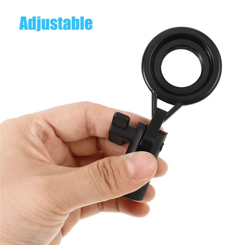 Black metal microphone stand clip with adjustable mount and an attached adjustable magnifying glass featuring a circular lens and textured grip.