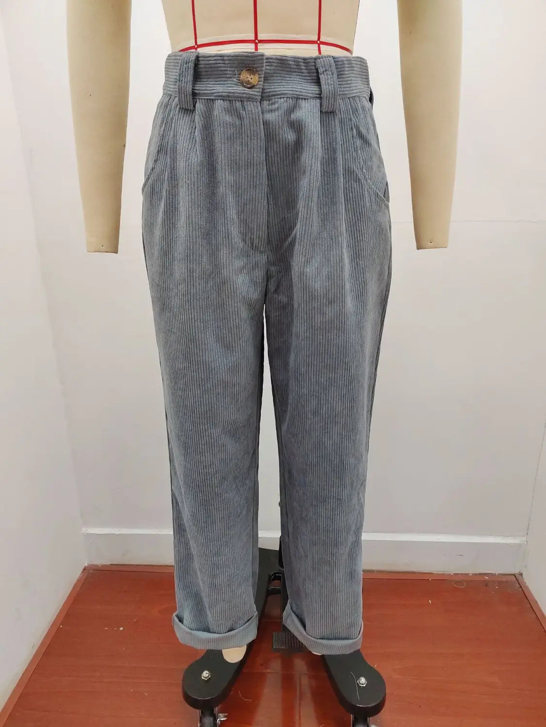 Pantalon en velours côtelé gris taille haute ample avec des rayures verticales et une ceinture boutonnée.