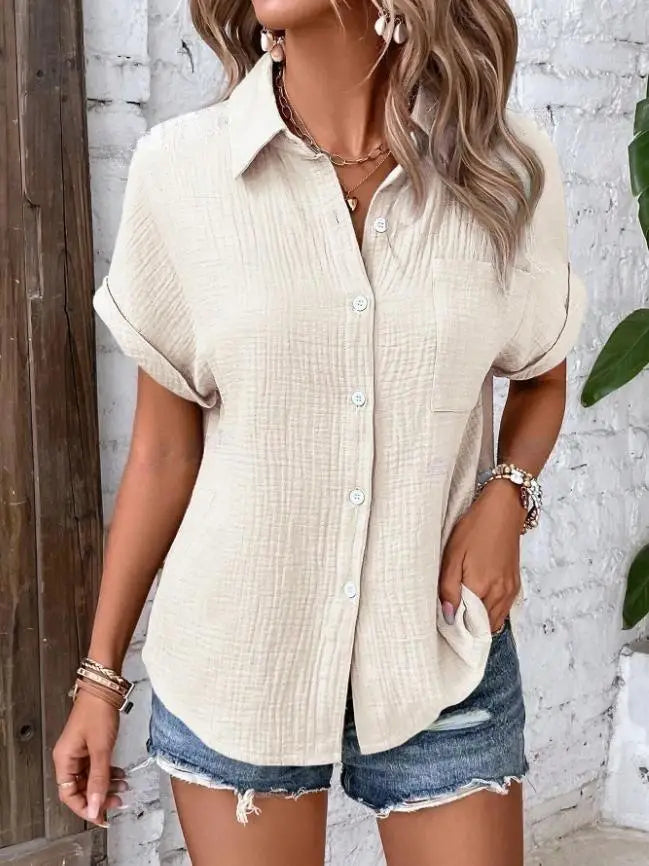 Beige textured cotton women short sleeve button up shirt with rolled sleeves and a chest pocket.