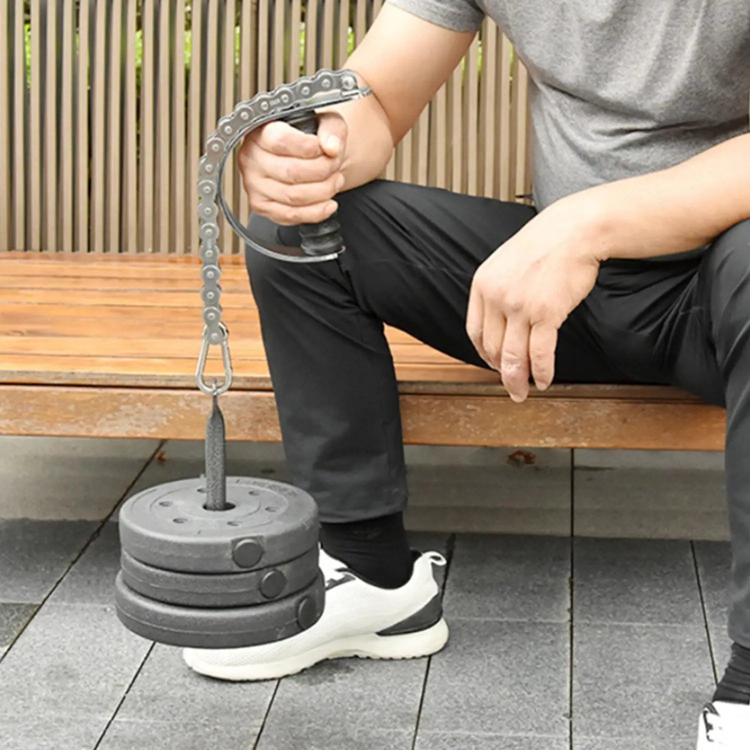 Gray metal chain resistance band with weight plates attached to a handle designed as arm wrestling training equipment forearm grip exerciser.