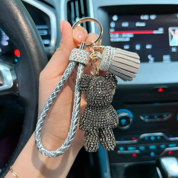 Silver braided keychain with a sparkling black rhinestone bear charm and a matching crystal-encrusted tassel attached to a leather strap.
