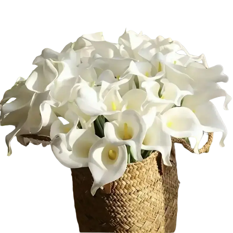 A bouquet of white calla lily artificial flowers with yellow centers arranged in a woven basket for home decor