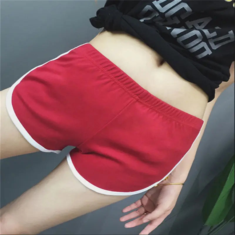 red sports shorts women with elastic waist and white trim designed for casual athletic use