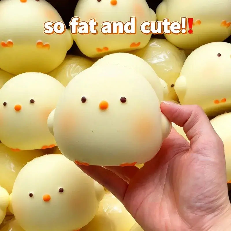 Un juguete blando tipo gallina gigante con forma de pollito, con detalles de pico y patas naranjas, para aliviar el estrés.