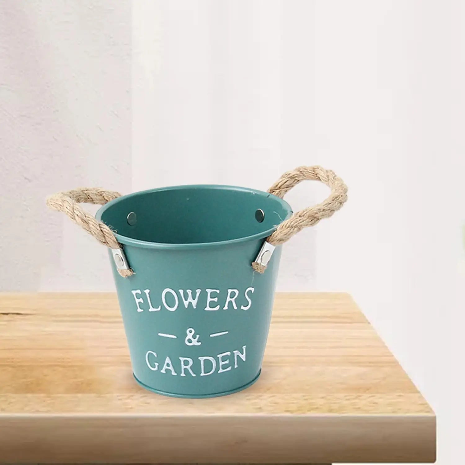 Teal-farbener Metall-Blumentopf mit Griffen aus Seil, Blumen und im weißen Gartenaufdruck, geeignet zur Verwendung als rustikaler Landhaus-Gartenpflanzen-Blumentopf.