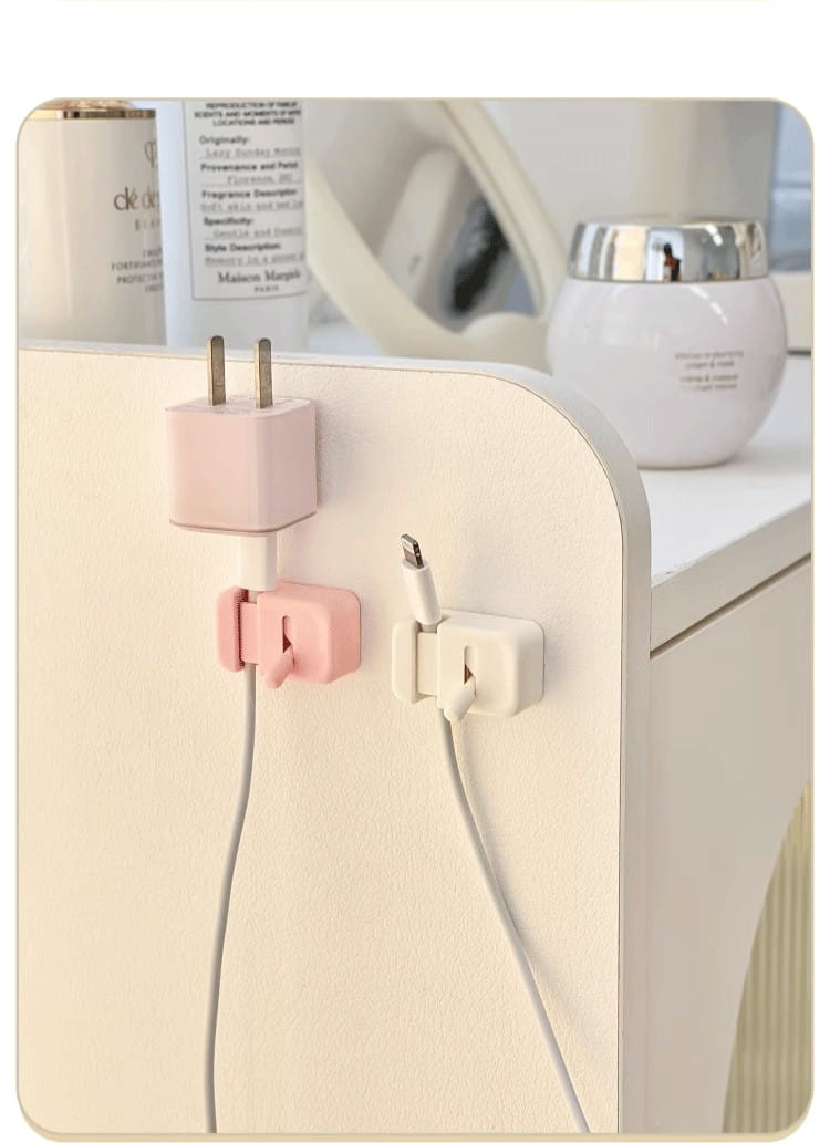 Pince de câble de bureau sans perçage, organisateur de cordons, présentant des supports de type pince en plastique rose et blanc pour les câbles de chargement