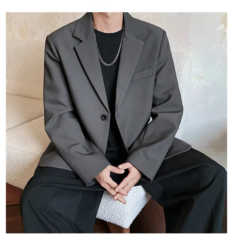 Ein elegantes dunkelgraues Herren-Casual-Sakko in Schwarz mit modernem Schnitt und Verschluss mit einem einzelnen Knopf.