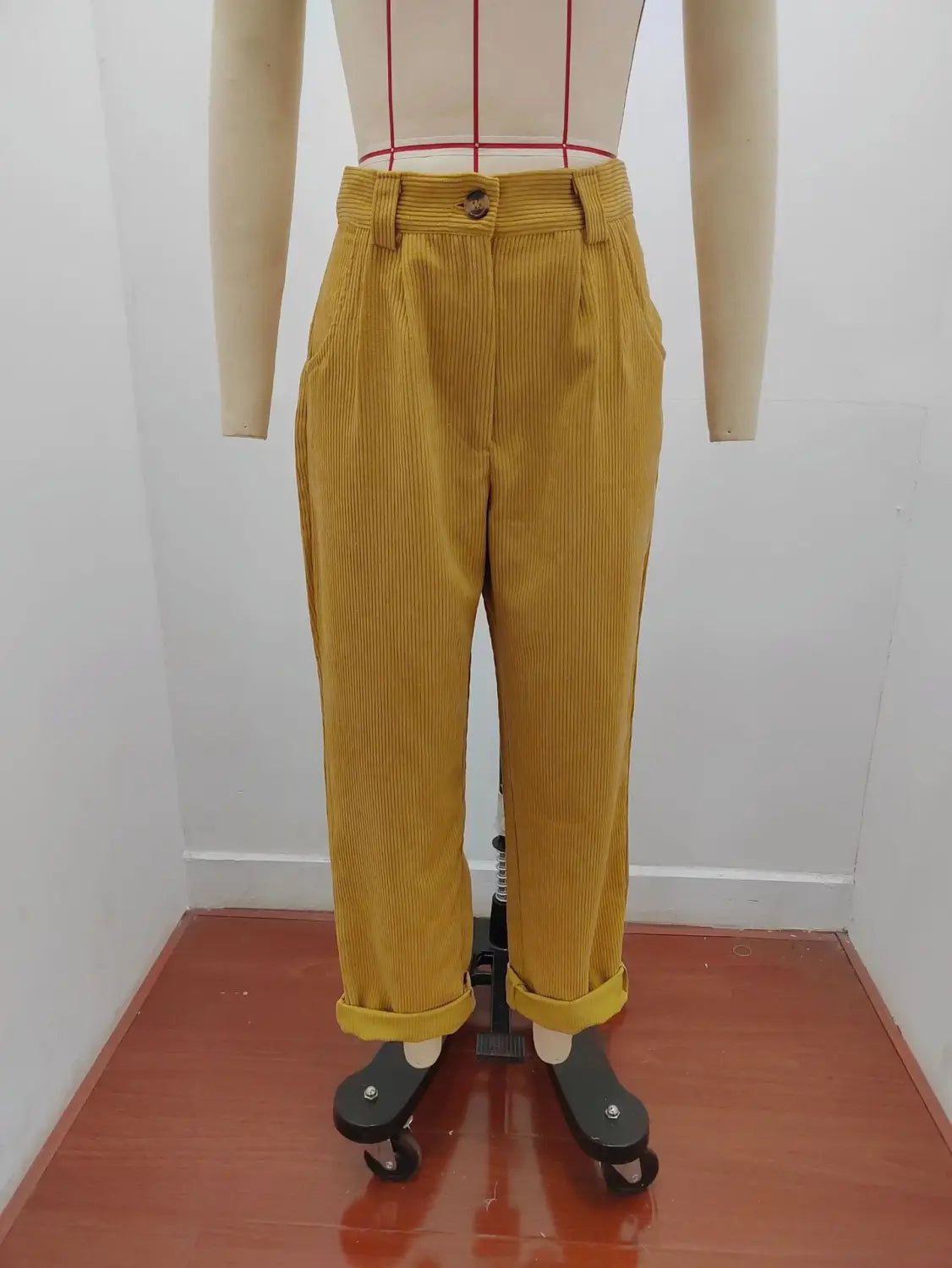 Pantalon en velours côtelé jaune moutarde taille haute ample avec bas retroussés, présenté de face.