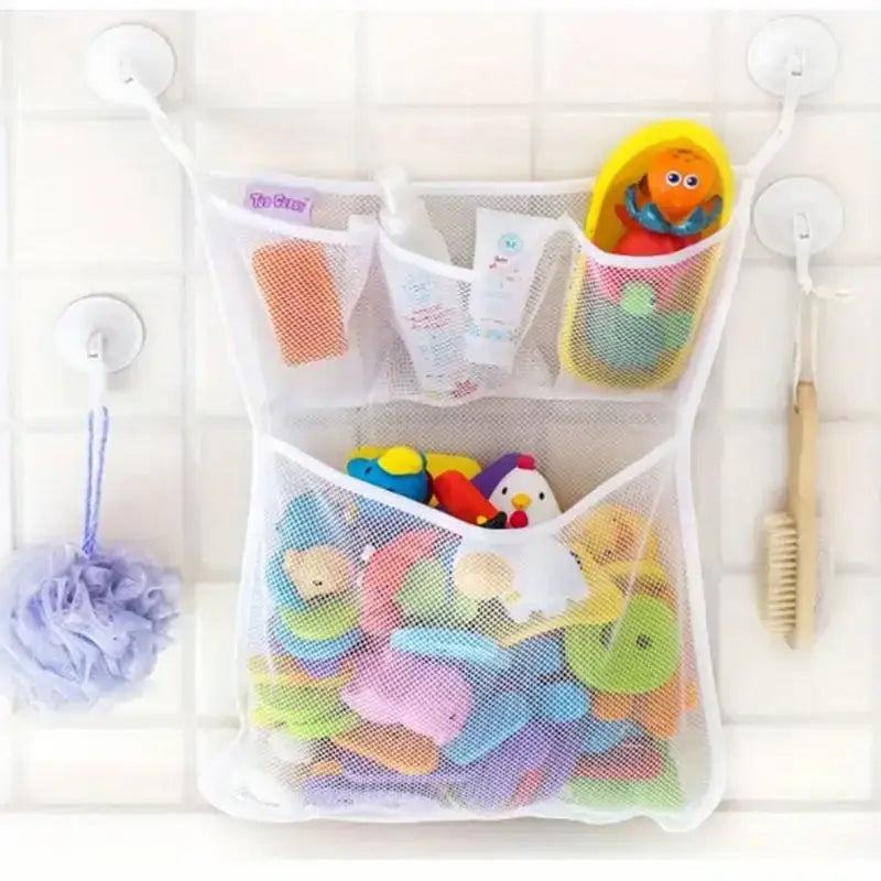 White mesh bath toy storage bag with suction cups featuring multiple compartments holding colorful rubber toys and toiletries.