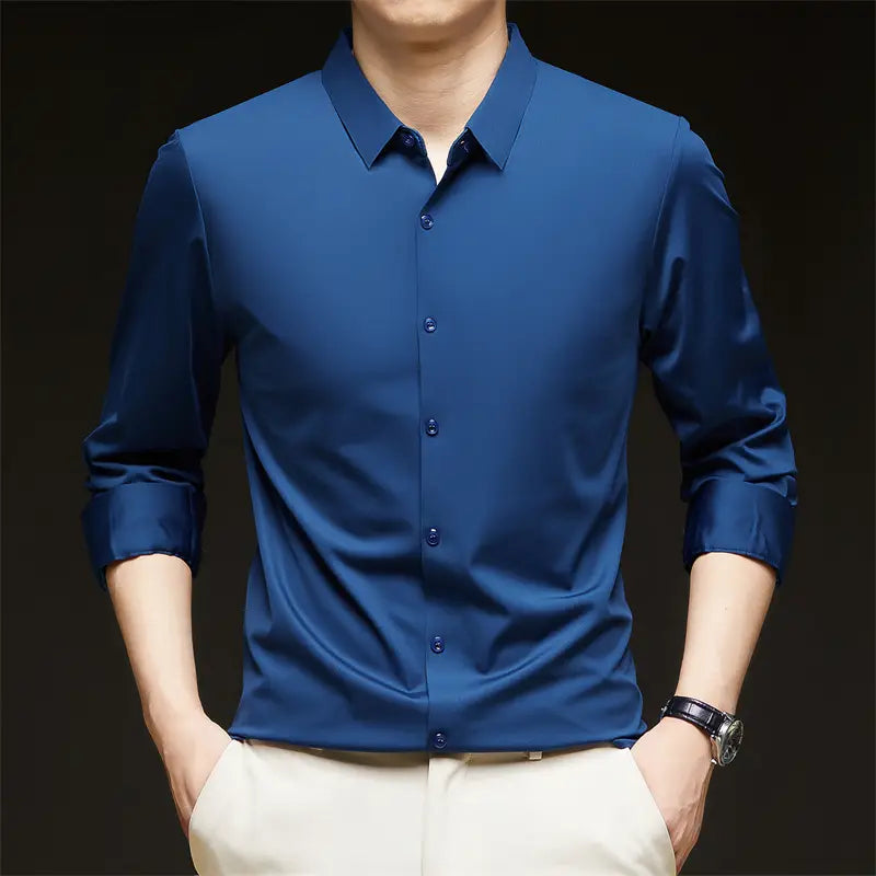 Camisa de vestir para hombre sin arrugas color azul marino elegante, con cuello impecable y mangas largas enrolladas con esmero.