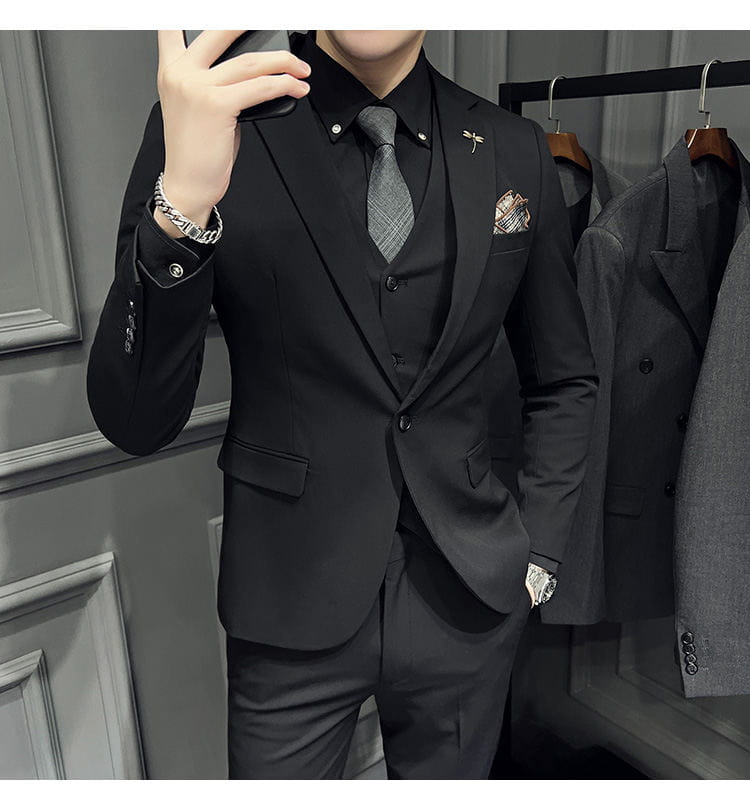 Ensemble de costume trois pièces noir slim fit pour homme, avec une texture discrète et un type de fermeture, comprenant 9 pantalons courts à la cheville et une coupe sur mesure épurée.