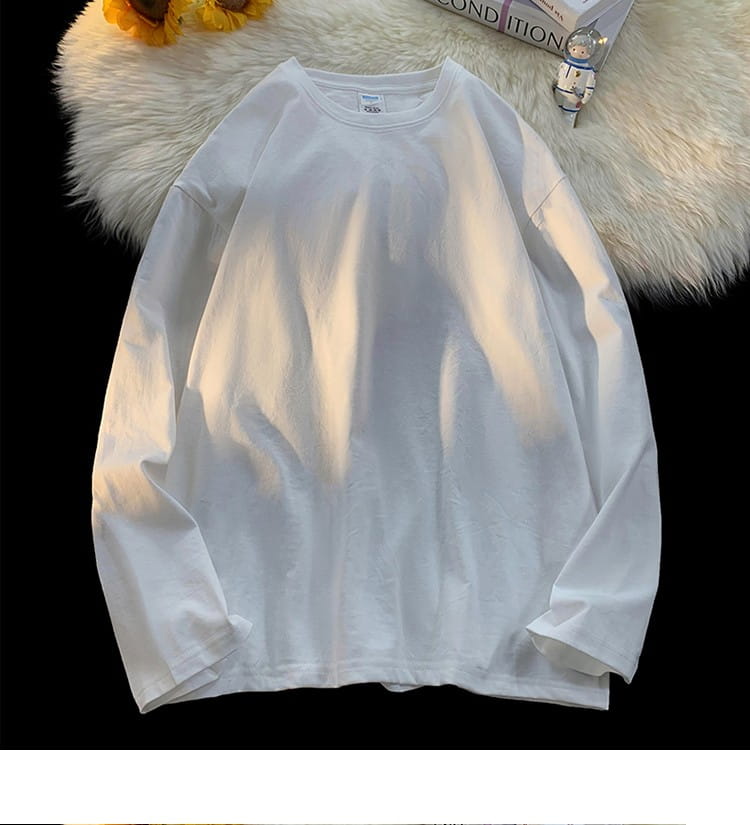 White oversized long sleeve blank t-shirt with a crew neck and soft slightly wrinkled cotton texture.
