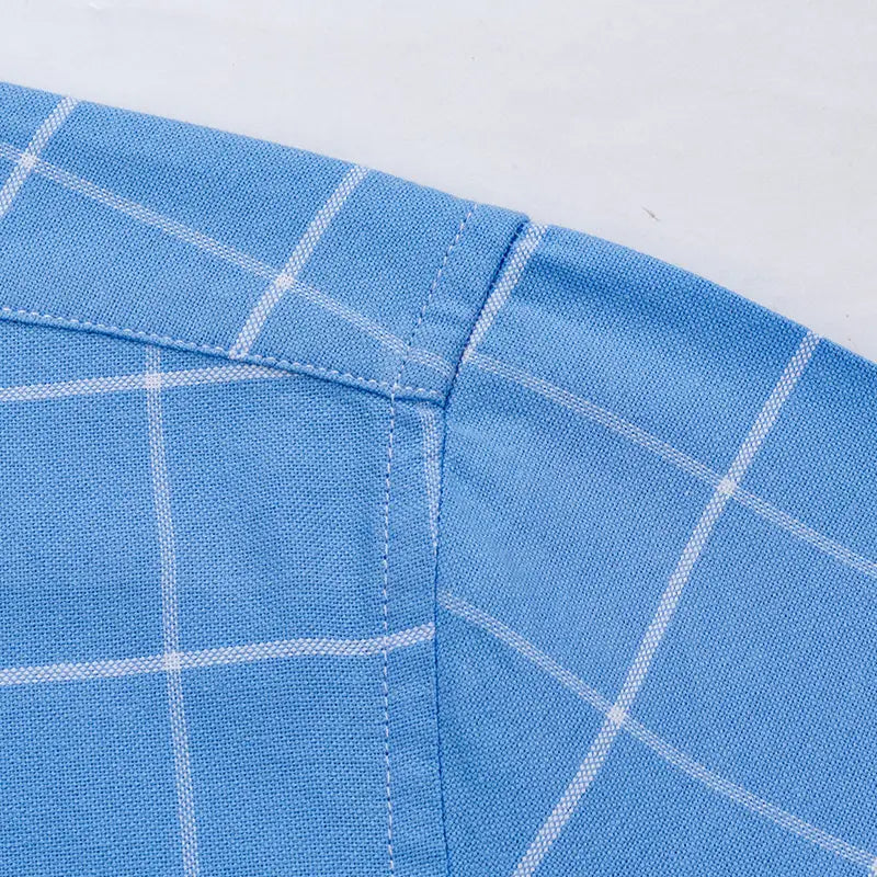 Men’s cotton oxford slim fit plaid shirt in light blue with a crisp white grid pattern and neatly stitched seams.
