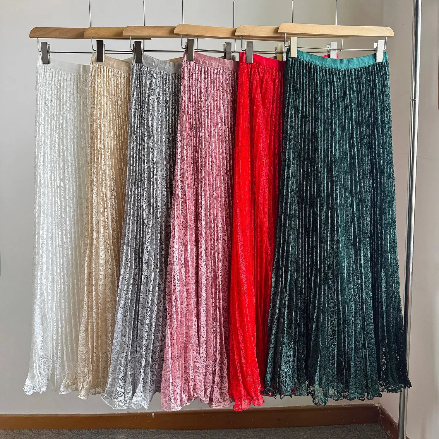 a collection of high waist pleated midi skirts in velvet material featuring colors white beige silver pink red and teal suitable for y2k streetwear.