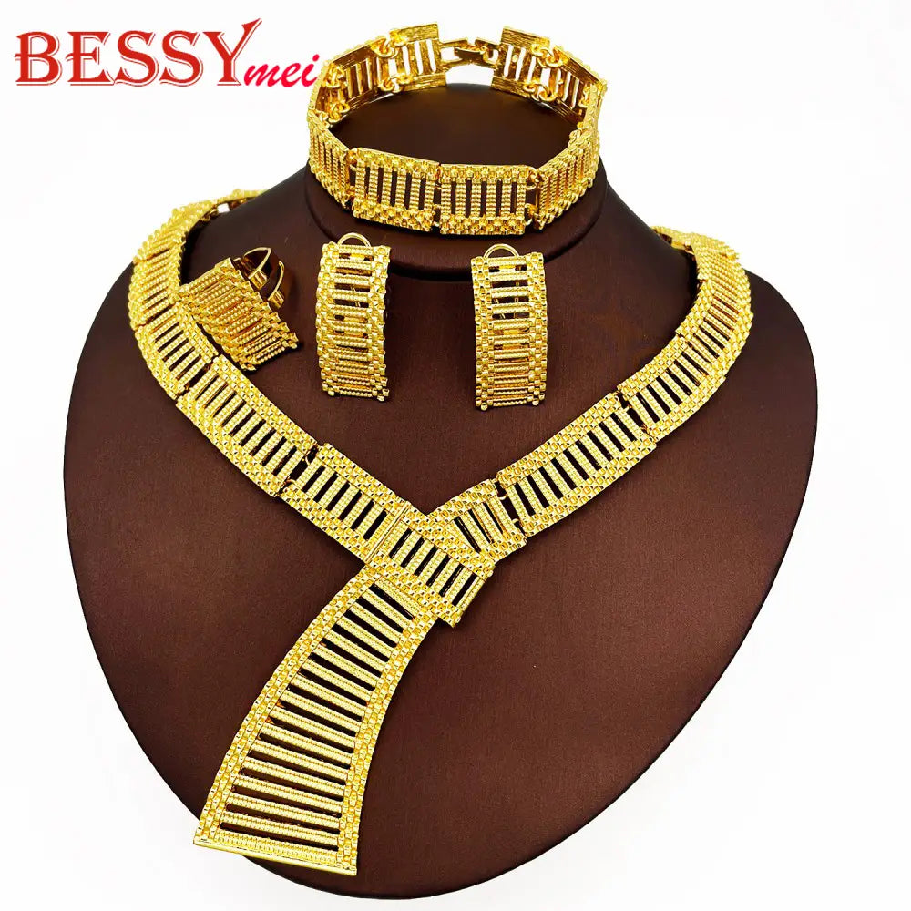 ensemble de bijoux africains de luxe plaqué or, composé d’un collier assorti de couleur or, finement conçu et doté d’un col en V marqué avec des détails de barre verticale, ainsi que d’un bracelet et de boucles d’oreilles.