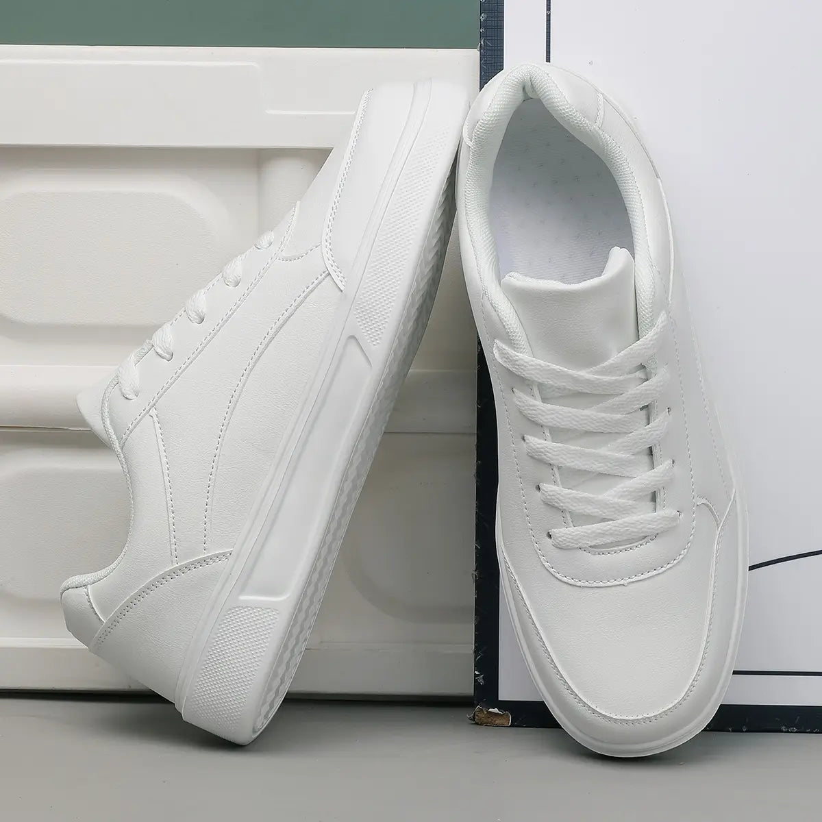 Men white leather minimalist low top sneakers featuring a clean design with matching white laces.