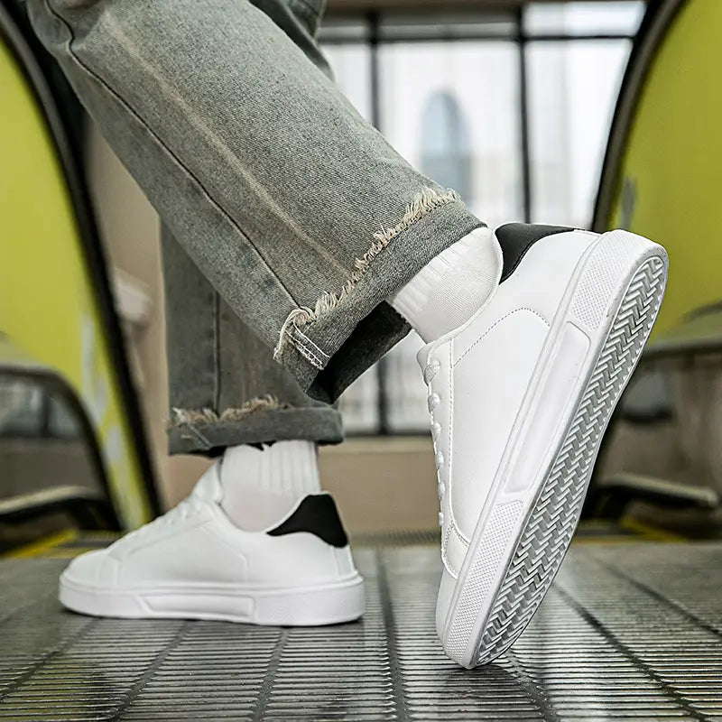 Weiße Ledersneaker im Freizeitstil mit einem klaren minimalistischen Design, weißem Low-Top-Aufbau und schwarzen Akzenten an Ferse und Zunge, ideal für sportliche Leichtgewichtsanwendungen.