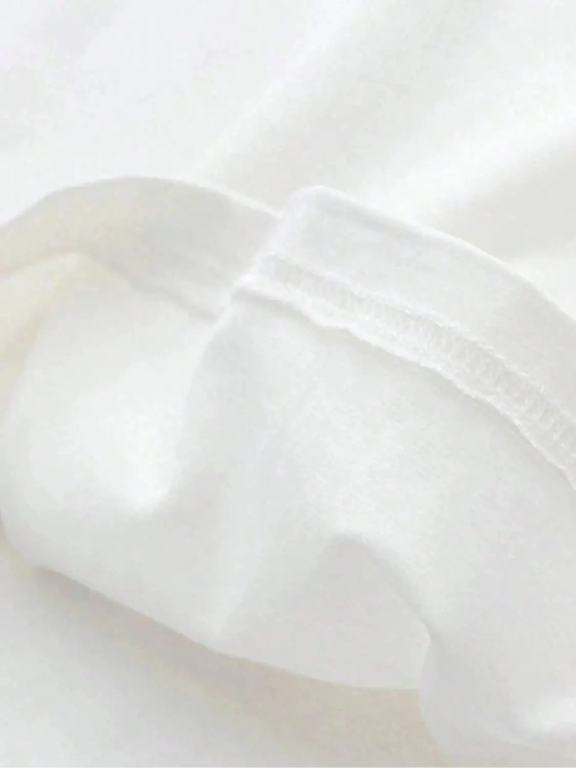 Graphic print oversized men short sleeve t shirt made of soft white cotton fabric with gentle folds and a subtle sheen.
