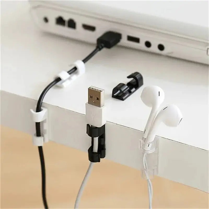Black and white cable organizer clips made of durable material holding cords securely to a desk edge for desktop cord management.