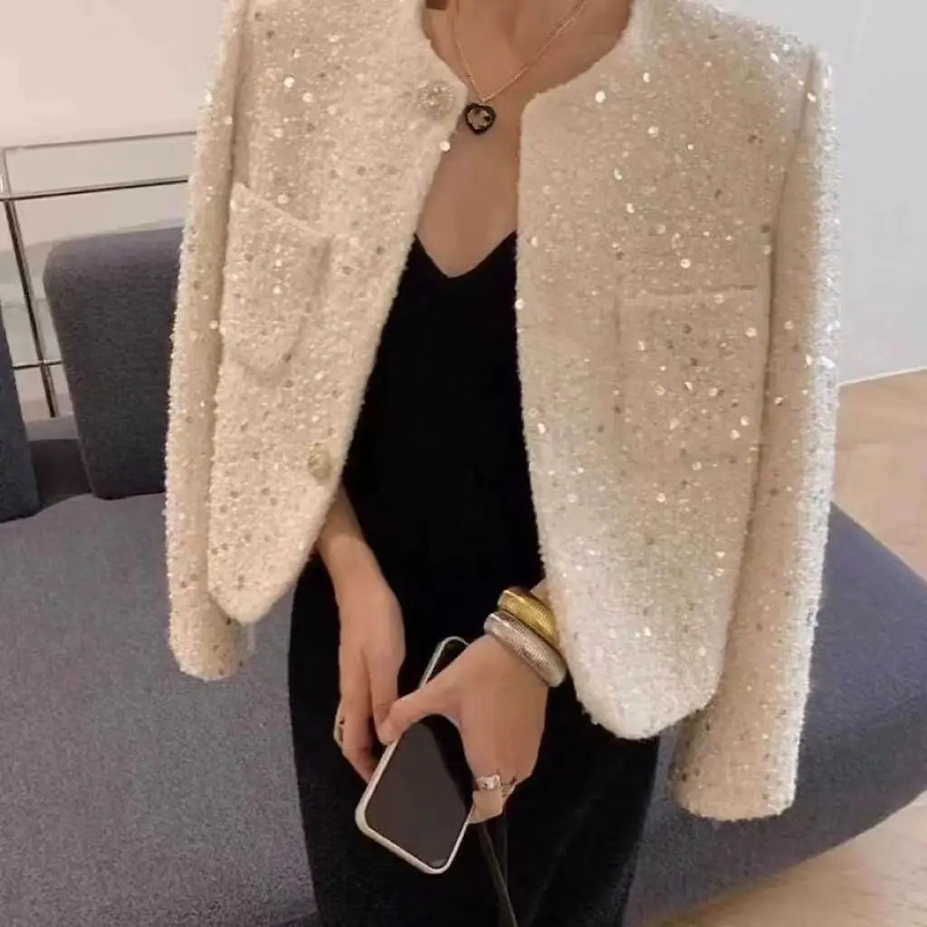 Cream sequined tweed blazer jacket featuring a cream color with sparkling sequins and a heart-shaped button detail.