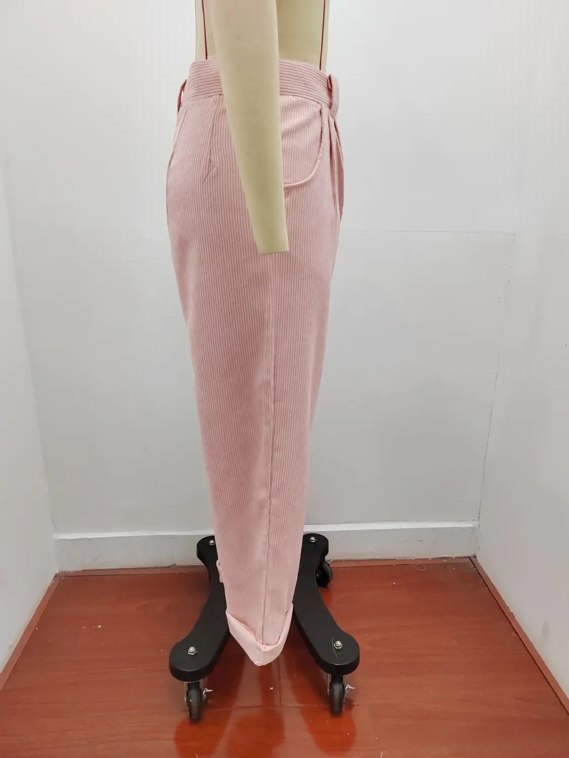 Pantalon en velours côtelé rose taille haute ample avec passants de ceinture assortis et poches latérales.