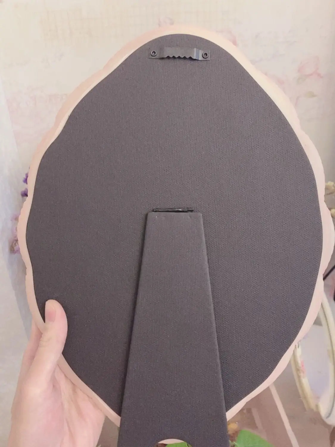 el reverso de un espejo de pared ovalado barroco color rosa, que muestra un marco redondo color melocotón con soporte de espuma negra y un soporte metálico para colgar, para decoración floral vintage