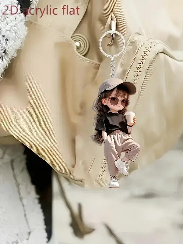 A cute acrylic girl keychain featuring a 2d cartoon design of a girl in a gray cap, sunglasses, black top, and beige pants holding a coffee cup.