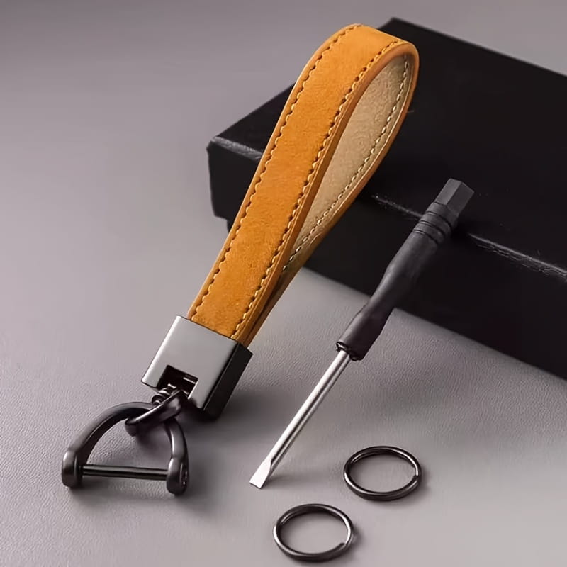 A tan suede leather car keychain with a minimalist design featuring a black metal d-ring and silver-toned clasp.