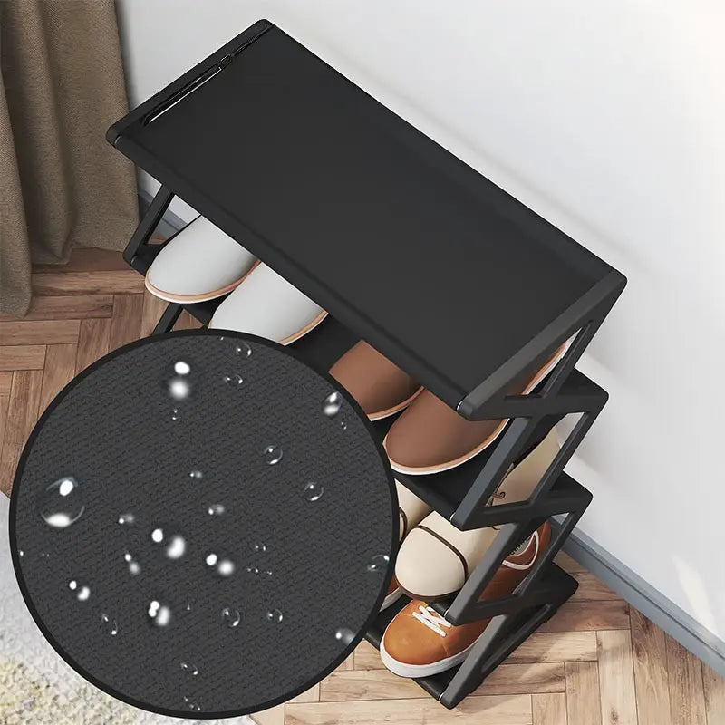 étagère à chaussures pliable noire à 4 niveaux avec surface texturée résistante à l’eau, conçue comme un organisateur de chaussures à plusieurs niveaux permettant de gagner de l’espace.
