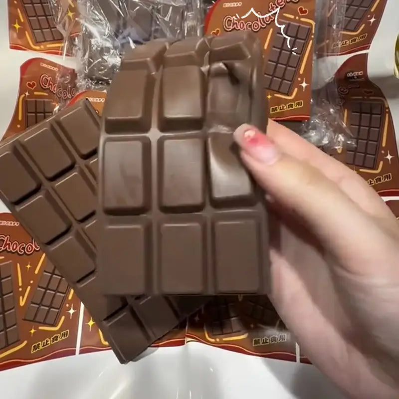a brown chocolate bar squeeze toy with a glossy surface and segmented design designed as a slow rising sensory fidget.