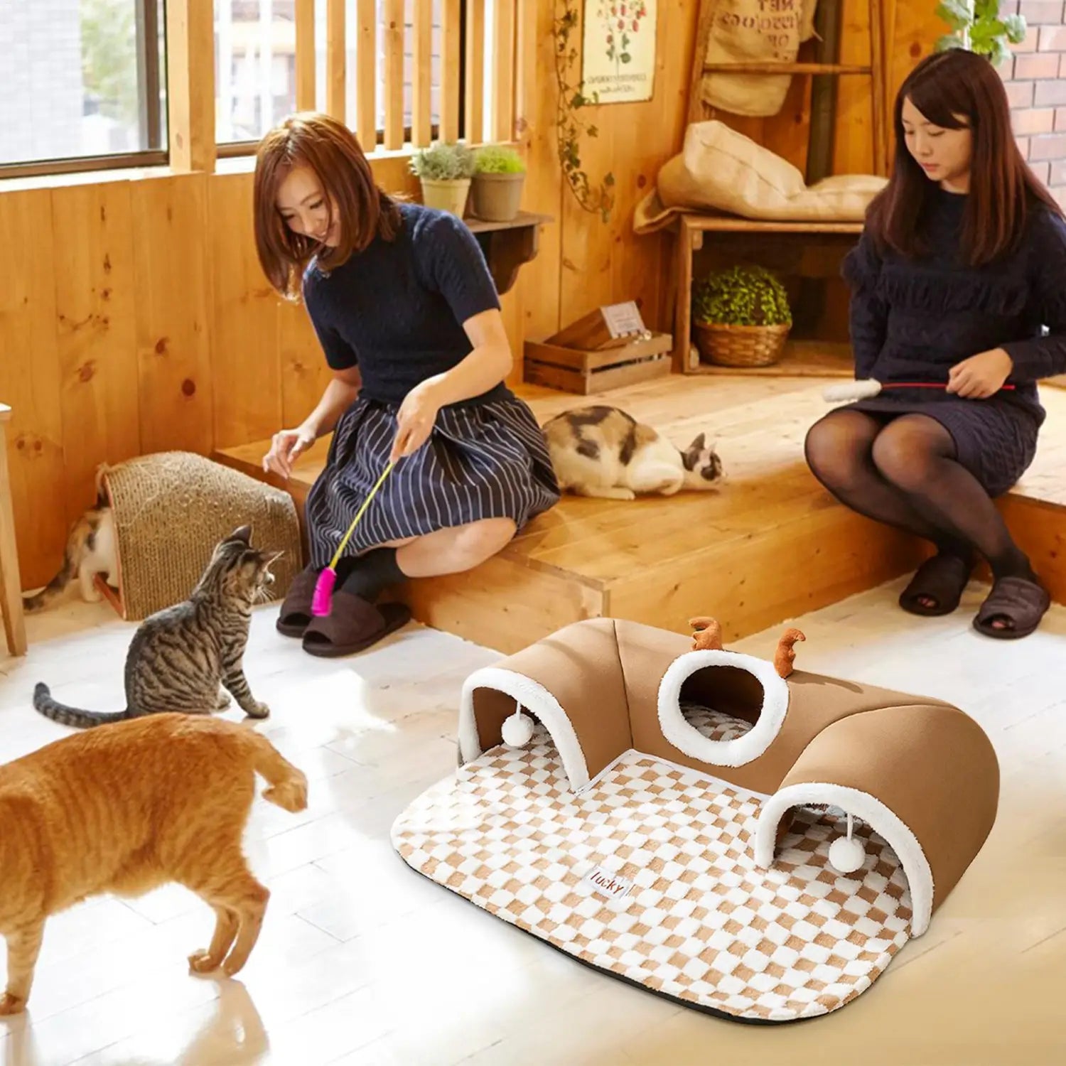 brown cat tunnel bed with white trim and checkered mat featuring plush corner hideaway and antler accents for cozy feline retreat
