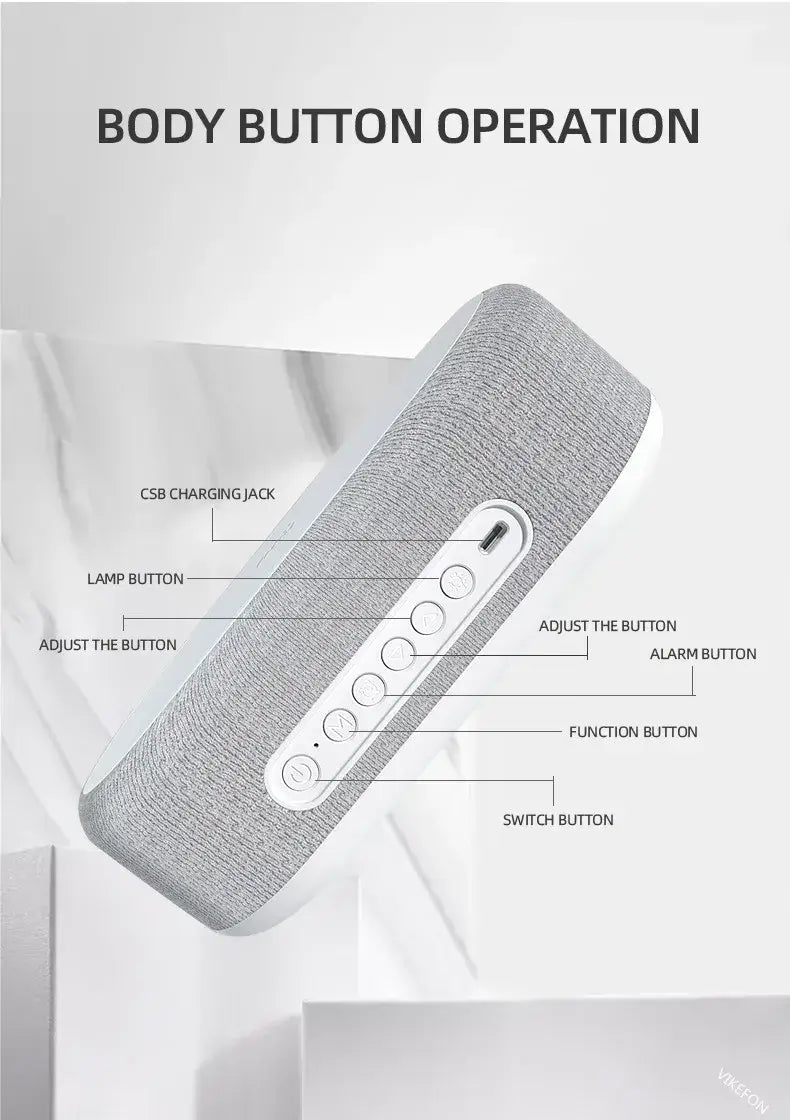 Reloj despertador de alarma con carga inalámbrica y visualización de la temperatura, con altavoz de tela gris con textura y panel de botones de plástico blanco con puerto de carga, que muestra su función de carga inalámbrica.