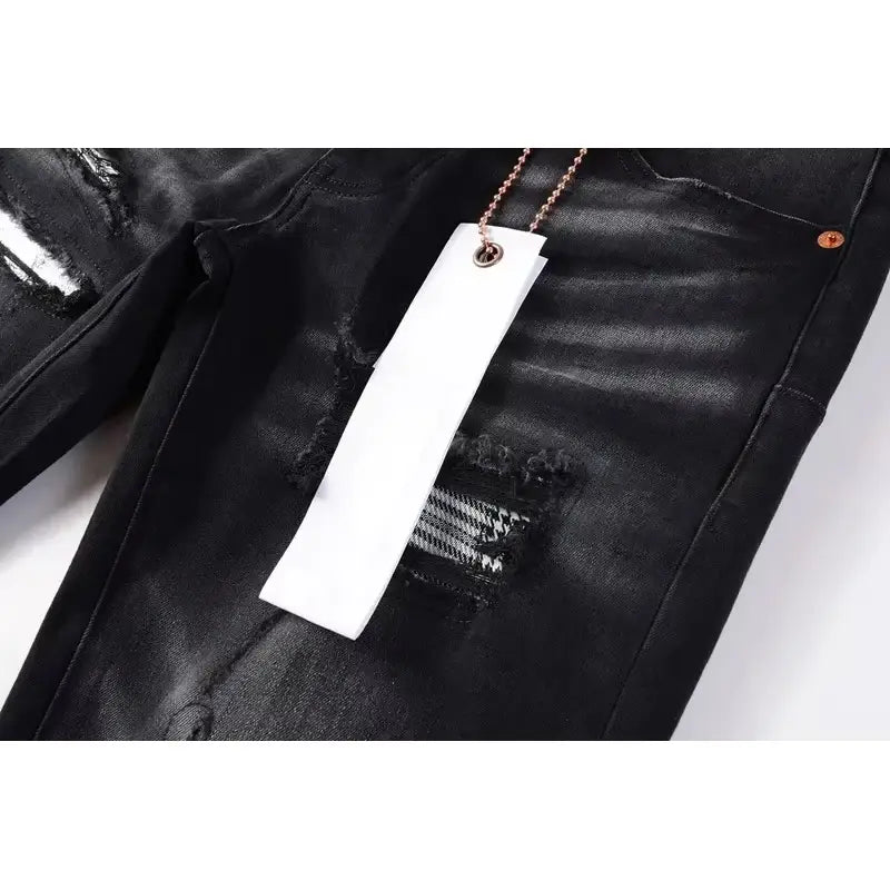 Black distressed patchwork skinny jeans featuring ripped patches and metallic hardware in denim material.