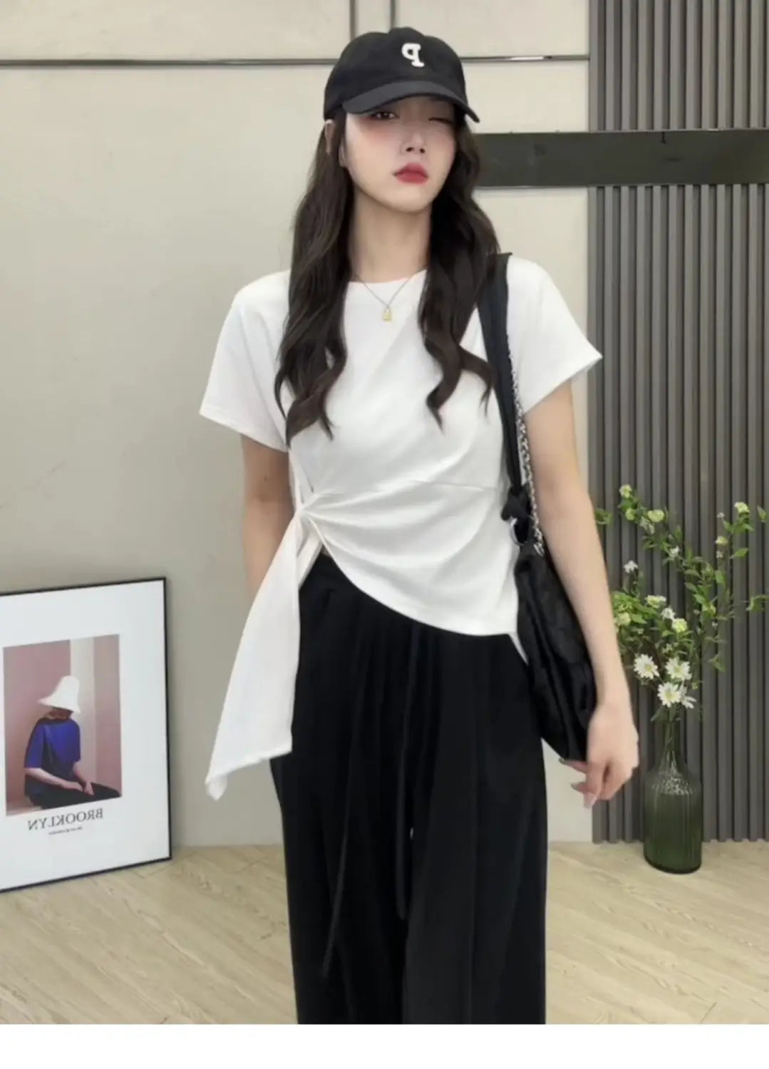 T-shirt blanc en coton à manches courtes pour femmes, avec un détail de lien latéral noué, conçu pour un port d’été décontracté.
