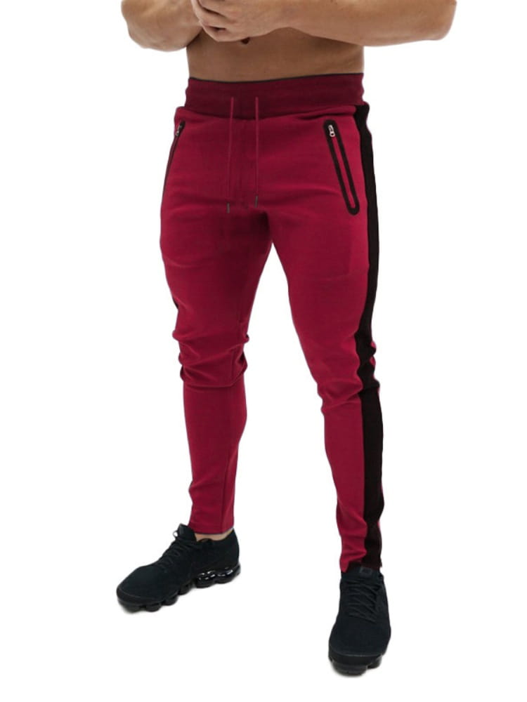 Joggers cargo casuales holgados para hombre en color burdeos, con franjas laterales negras y bolsillos con cierre diseñados para uso atlético.
