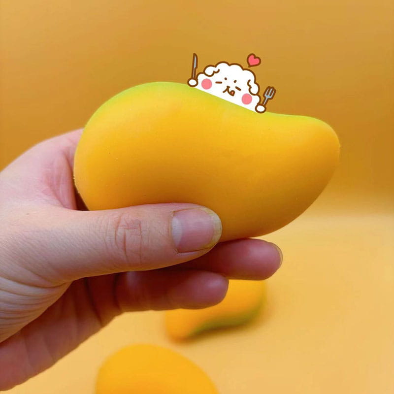 Un jouet antistress souple jaune en forme de mangue, doté d’un mignon personnage de dessin animé qui dépasse par le haut, conçu pour soulagement du stress et utilisation lors d’une fête d’anniversaire.