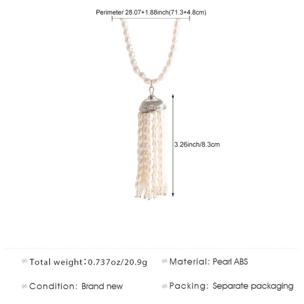 Un délicat collier-ras-de-cou à pendentif pompon en perles, présentant des rangées retombantes de perles d’imitation blanches avec une coupelle en métal à ton argenté, conçu comme une longue chaîne de pull-over.