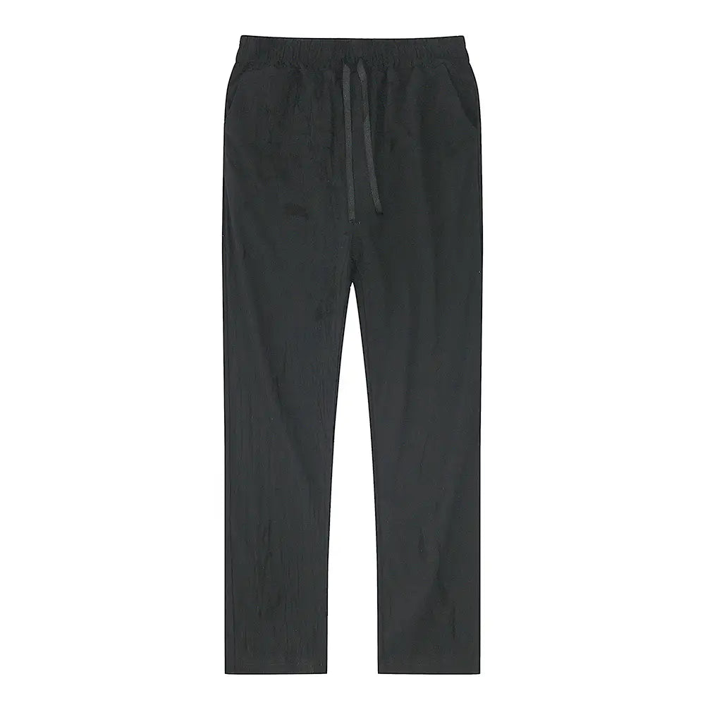 black cotton linen drawstring trousers featuring a relaxed fit and subtle texture for breathable casual wear