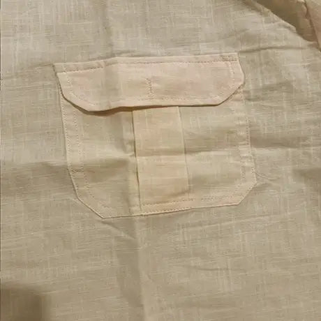 Men linen short sleeve shirt in beige featuring a single patch pocket with matching stitching and subtle linen texture for casual summer wear.