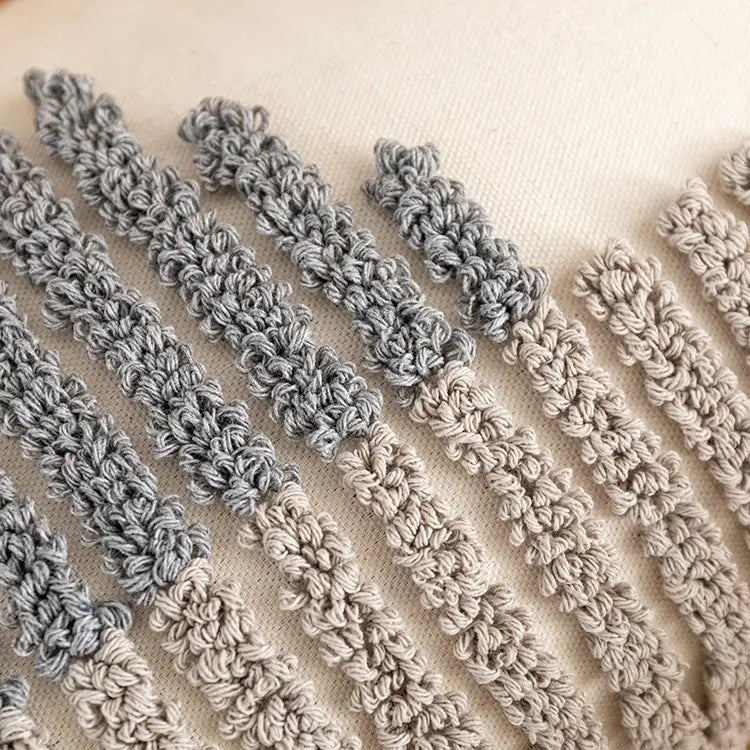 Grau-beige gehäkelte Stoffstreifen mit einem strukturierten, gerippten Muster auf einem Kissenbezug 45x45 cm, Boho-Tufting, graue Heimdekoration.