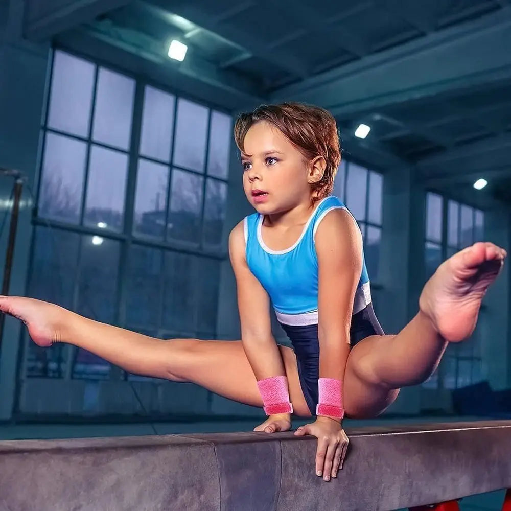a young girl in a blue and white leotard performs on a balance beam wearing a kids gymnastics grips and wristbands set designed for hand protection and support during routines