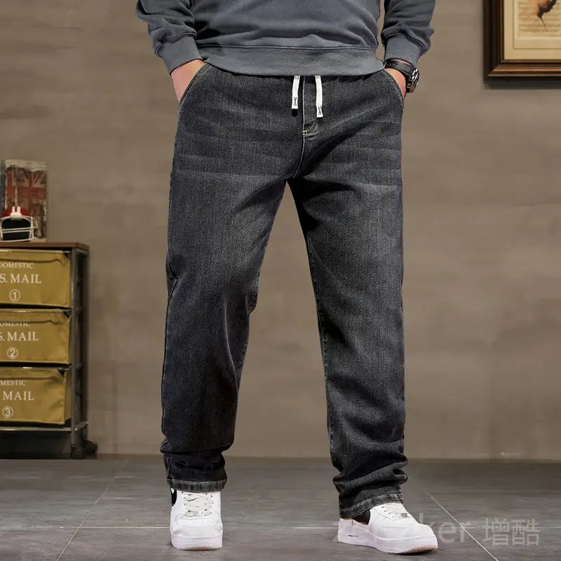 plus size elastic waist loose straight jeans in dark-wash denim featuring white drawstrings at the waistband.
