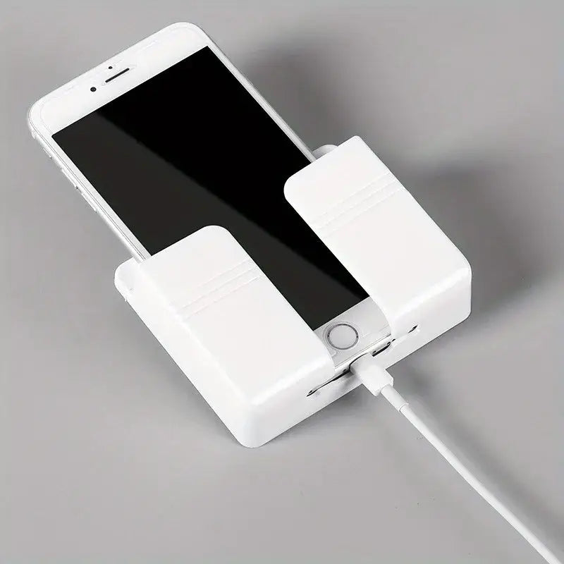 White plastic wall mount phone charging holder with cable plugged in securely holding a smartphone.