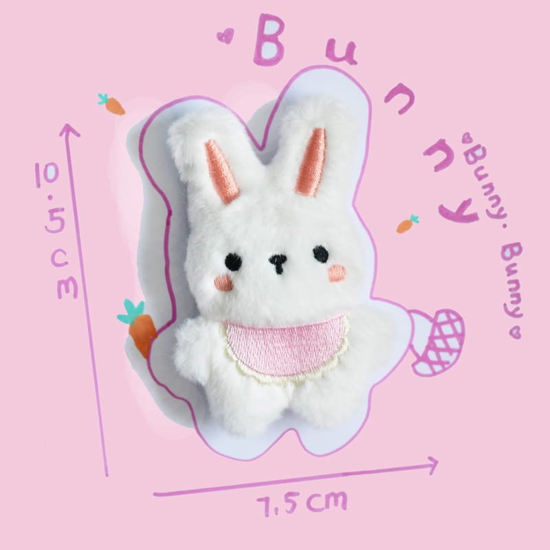 ピンクの刺繍の耳とほほ、レースで縁取られたピンクのよだれかけが特徴の、インタラクティブな笛（スウィーカー）付きのソフトな白いウサギの犬用ぬいぐるみです。ペット向けの遊びにご使用いただけます。
