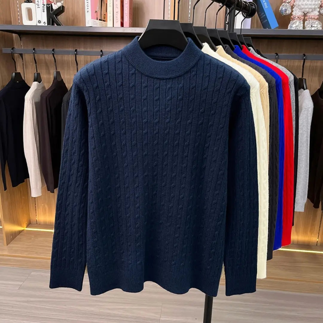 Dunkelblauer Herren-Zopfstrick-Pullover mit geripptem Rundhalsausschnitt und langen Ärmeln, dargestellt auf einer Schaufensterpuppe.
