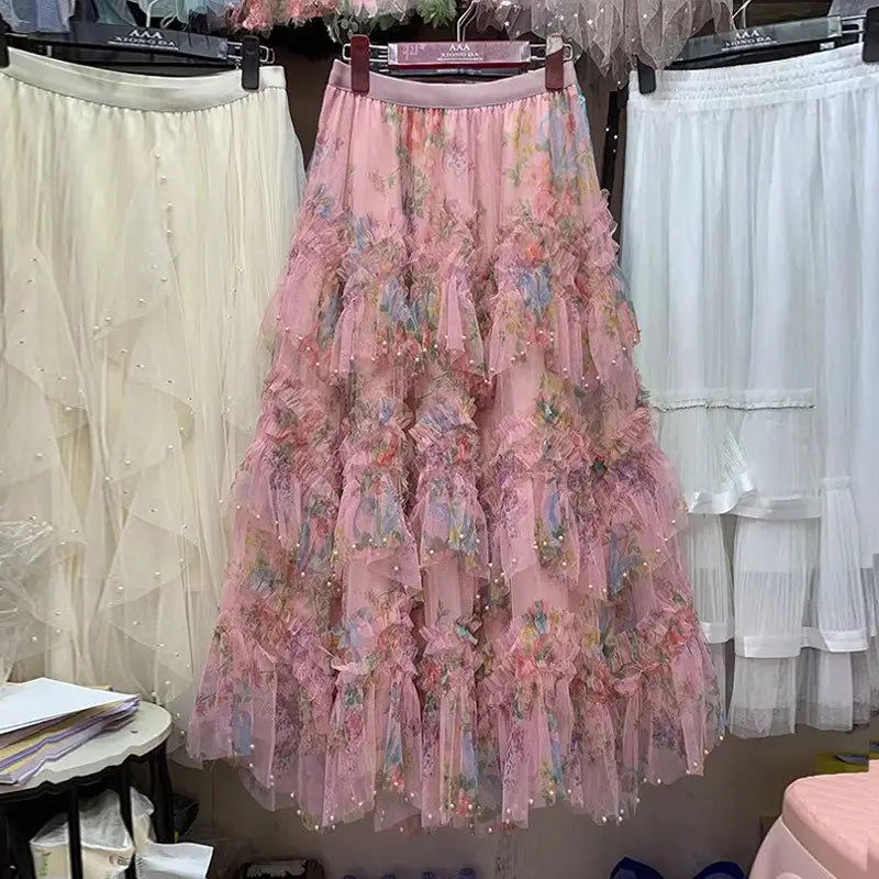 Una falda de tul floral fairycore delicada en color rosa con capas escalonadas, bordado floral y ribete de perlas en estilo y2k.