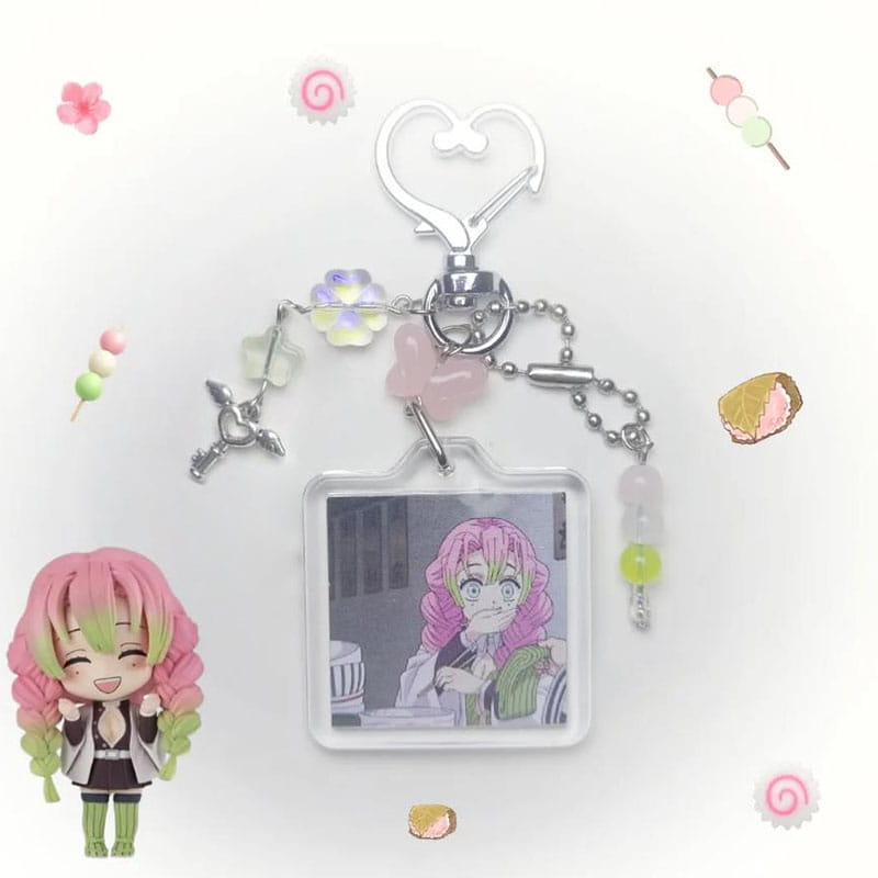 A clear rectangular Mitsuri Kanroji anime keychain featuring a printed character with pink and green hair, silver charms, pastel beads, and a heart-shaped metal clasp.