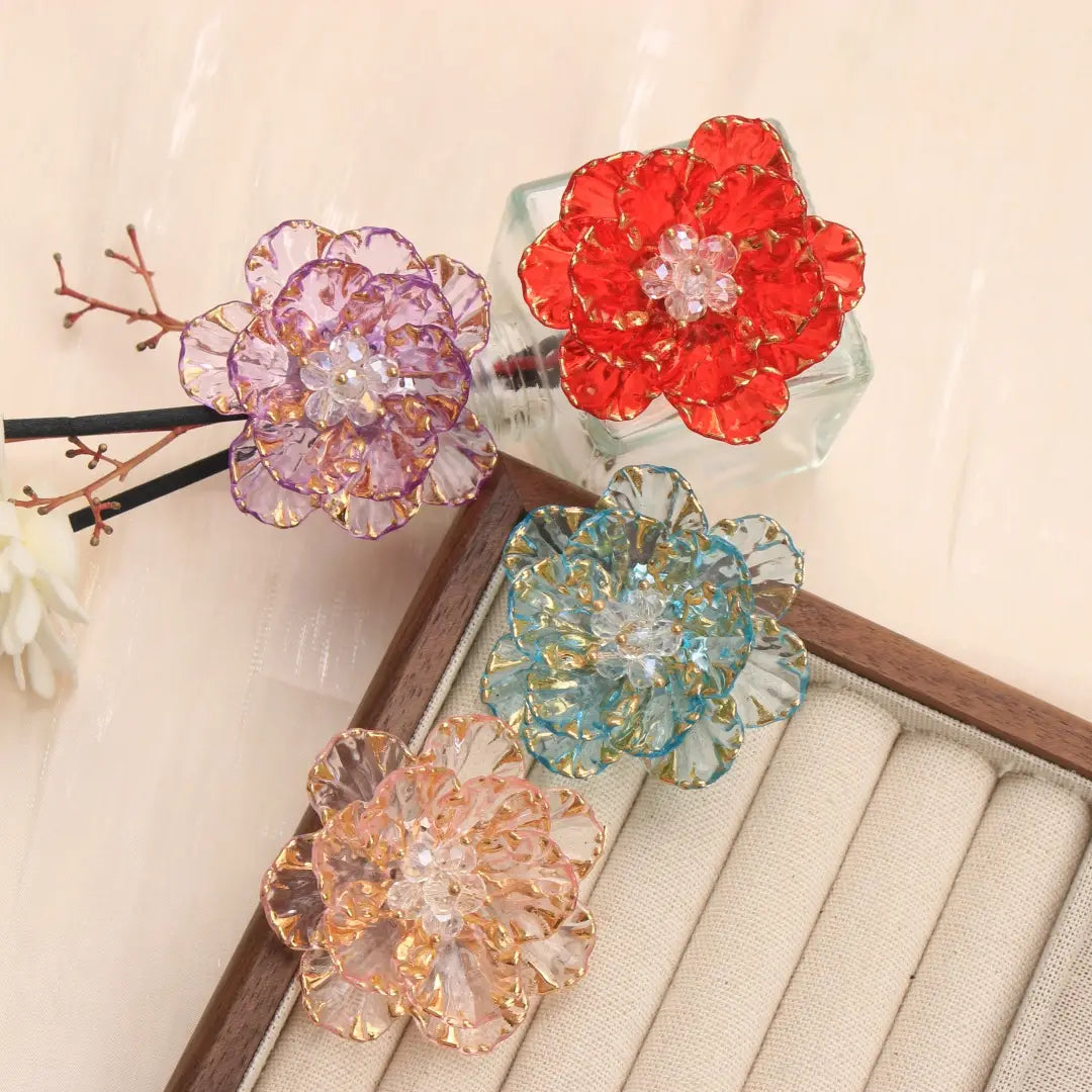 Broche en forme de fleur de cristal, accessoire de mode, présentant des pétales de cristal multicolores vibrants avec une bordure dorée et des centres scintillants.
